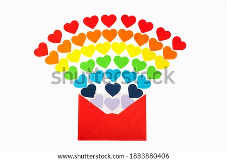 Open red envelope with lots of rainbow colors hearts coming out and spread over the white background as love letter. Valentine's Day concept. Top view, Flat lay. LGBT symbol