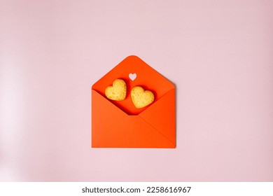 open red envelope for valentine with heart shaped cookies on pink background
 - Powered by Shutterstock