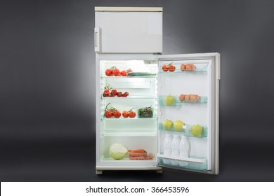 Open Refrigerator Full Of Fresh Food Isolated Over Gray Background