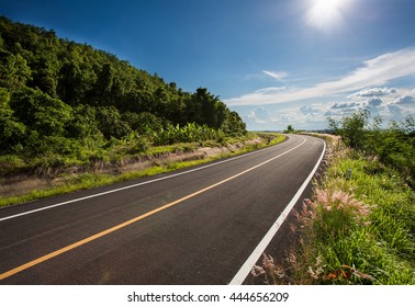 open road. Asphalt road through the green field and clouds on blue sky in summer day. Beautiful grassland road in Thailand.Highland road. - Powered by Shutterstock