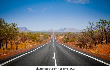 The Open Road In Kimberly, Western Australia. Straight Single Lane Asphalt Road Stretching Into The Distance With Mountains In The Background. Holiday Adventure.
