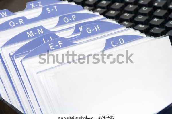 Open rolodex organizer with computer keyboard\
in the background
