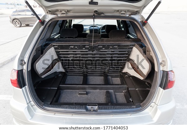 Open roomy luggage compartment\
of a gray Japanese hatchback with black trim after cleaning and\
washing pre-sale preparation. Cargo taxi for transporting\
things.