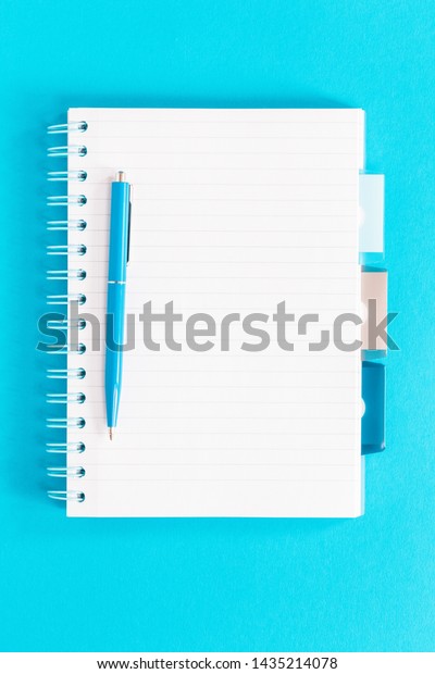 Open ruled\
spiral notebook with dividers. office and school stationery on\
pastel trendy background as border. Flat lay with copy space for\
back to school or education and craft\
concept