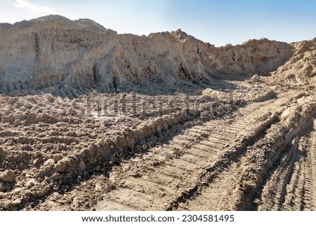 Open sand pit, for sand extraction during construction. The texture of sand and traces of the tread of large cars. Sand for construction work. 