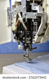 Open sewing machine with exposed internal mechanism and needle area. Close-up of maintenance, repair, and hands-on analog hobby in home sewing workspace.