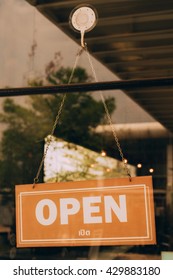 Open Sign Broad Through The Glass Of Window At Coffee Shop