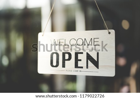 Open sign broad through the glass of door in cafe with colorful bokeh light abstract background. Business service and food concept. Vintage tone filter effect color style.