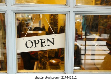 An Open Sign Hanging In A Door Of A Shop