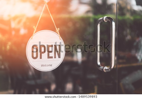 Open sign hanging front of cafe with\
colorful bokeh light abstract background. Business service and food\
concept. Vintage tone filter effect color\
style.