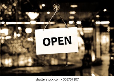 A Open Sign Hanging In A Shop Window