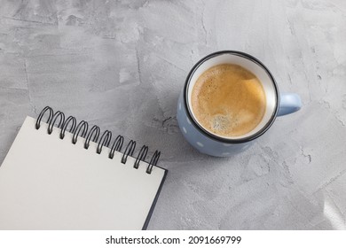 Open sketchbook or notebook, coffee on gray background