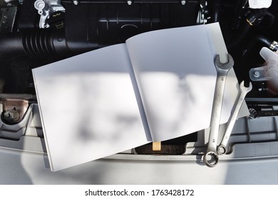 Open Softcover Book Lying On A Car Engine Mockup.