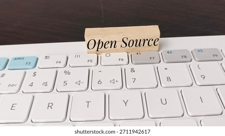 Open source software concept with wooden block on computer keyboard, illustrating technology development, programming, coding, IT solutions, and digital innovation. 