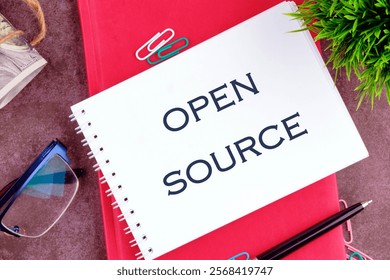 OPEN SOURCE words in a mini notebook on a business book, close-up. Copy space.