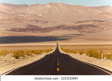 open straight road to nowhere in a desert landscape in Death Valley - Shutterstock ID 1315133987