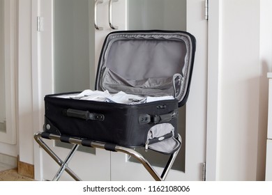 Open Suitcase On Luggage Rack In Hotel Room