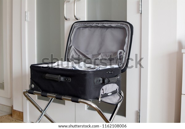 Open Suitcase On\
Luggage Rack In Hotel Room