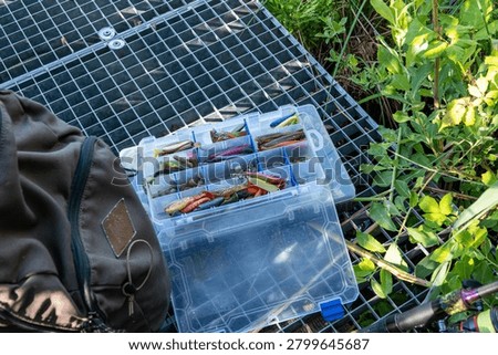 Open tackle box with soft plastic fishing lures and fishing accessories.
Close-up of an open fishing tackle box filled with soft plastic lures, jig heads, and accessories prepared for freshwater fishing.
