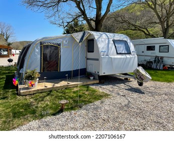 An Open Tent In Front Of A Travel Trailer At A Caravan Campsite. Caravan Camping Concept. 