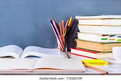 Open textbook and hardback stacked with pencils on the table. The concept of intelligence comes from education. focused on the textbook. - Shutterstock ID 776181709