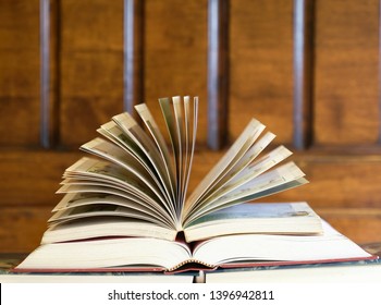 Open textbook on top of books with wood background, an education concept - Shutterstock ID 1396942811