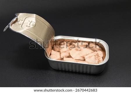 Open tin can with cod liver in oil on dark background. Concept of canned seafood healthy diet protein food and omega 3 nutrition