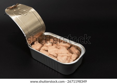 Open tin can with cod liver in oil on dark background. Concept of canned seafood healthy diet protein food and omega 3 nutrition