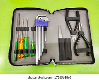 Open Tool Bag With Tools For Electrician And Fitter On Green Background