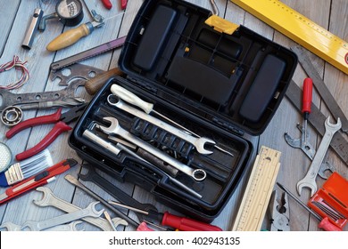 Open The Tool Box And Tool Around On The Wooden Floor, Top View. Locksmith And Carpentry Tools.