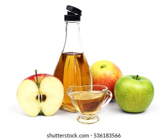 The open transparent full bottle and cup of Apple cider vinegar and a few different varieties of apples isolated on a white background. - Shutterstock ID 536183566