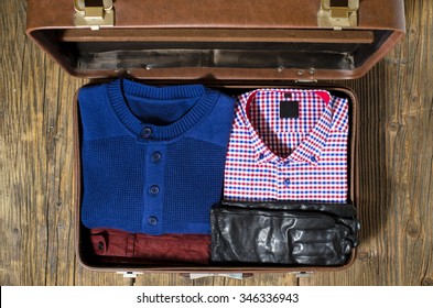 Open Travel Suitcase With Casual Man Clothes. Top View