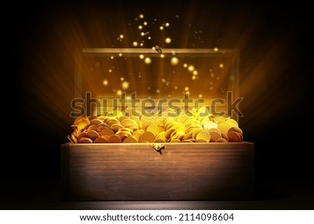 Open treasure chest with gold coins on table against black background
