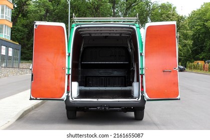 Open Trunk Of A Modern Cargo Van. Rear View Of A Modern Cargo Van Vehicle With Open Trunk And Loading Compartment.