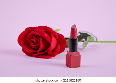 Open Tube Of Red Satin Finish Lipstick And Red Rose Flower