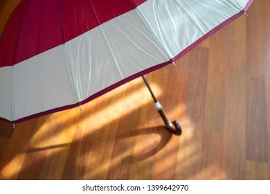 Open Umbrella Stands On A Sunny Laminate Floor Closeup