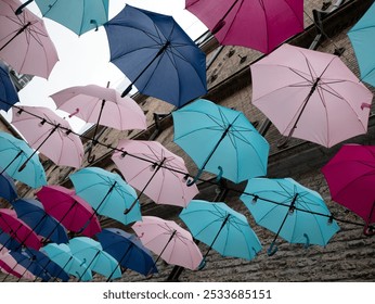 A lot of open umbrellas hanging in the air, selective focus. Street decoration concept - Powered by Shutterstock