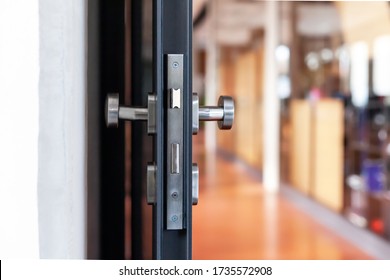 Open Unlocked Doors In An Empty Secure Vacant Corporate Business Area, Nobody, Door Knob Lock Side Closeup. Door Left Open, Office Building Security Abstract Concept.  Simple Entrance And A Hallway