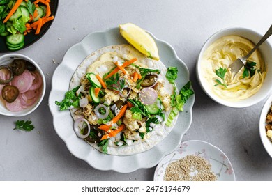 Open vegan tortilla wrap with roasted cauliflower, green veggies, and layered with hummus spread in a plate. Top View. Flat lay Healthy vegan food concept. - Powered by Shutterstock