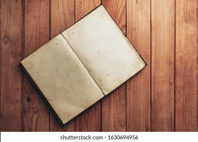 Open Vintage Book On A Red Wooden Table Background. Top View.