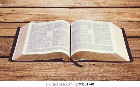 Open Vintage Christian Bible On Wooden Desk