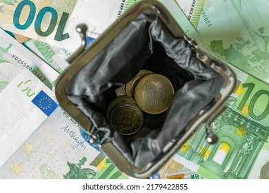 An Open Wallet With Forint Coins On The Background Of 100 Euro Banknotes