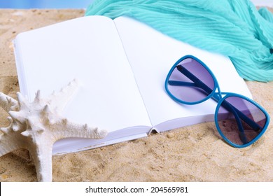 Open white book on sand background - Powered by Shutterstock