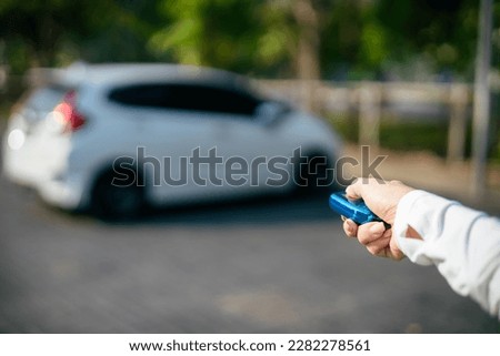 Open the white car on Interlligent key system, Girl opens his car door with the control remote key.