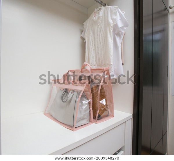 Open
white closet with clothes and bags and empty
space