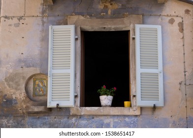 An Open Window With A Beautiful Mother Mary Painting Near It Along An Alley Of Montefortino, Italy