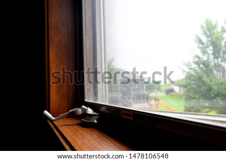 Open window with turn knob on dark wood frame