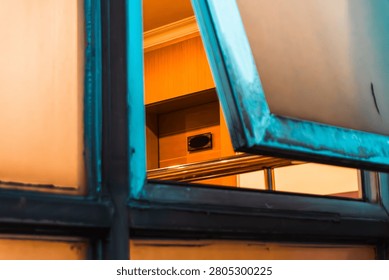 Open window with warm light inside a contemporary urban building.