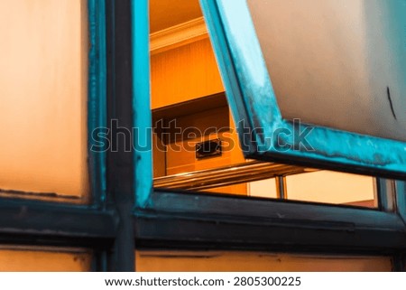 Open window with warm light inside a contemporary urban building.