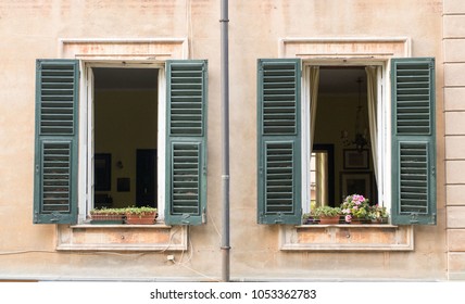 Open Windows Of An Apartment With Flower Decorations On The Window Sills